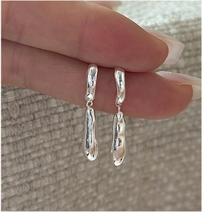 Macro shot of S925 sterling silver drop earrings with irregular lava texture design