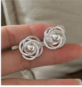 Detail of S925 sterling silver spiral earrings with central bead on soft background