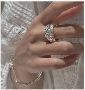 Detailed macro view of a vintage silver wide band ring with an intricate braided texture