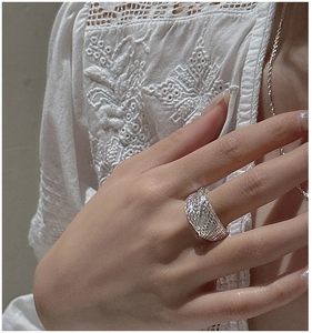Detailed view of a wide S925 silver woven texture ring worn on a finger with lace detail