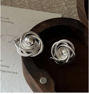 Close-up of vintage S925 silver twisted rope stud earrings with a central metal bead