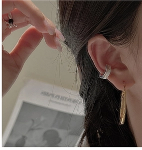 Detail view of S925 silver clip earrings and gold drop earring on a model