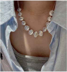 Close-up of S925 sterling silver necklace with eleven oval moonstones on a model