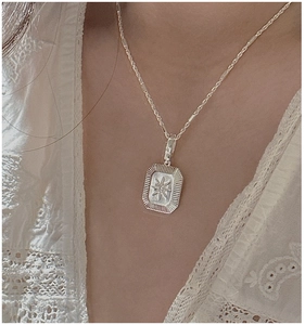Detail of S925 sterling silver starburst rectangle pendant necklace on model
