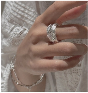 Macro detail of a wide hollow S925 silver mesh ring with polished woven texture design