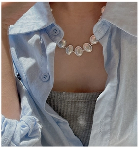 Macro detail of S925 sterling silver matte oval link necklace on linen background