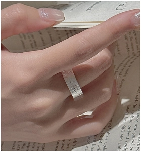 Macro detail of wide S925 sterling silver ring with star engraving and brushed metal texture