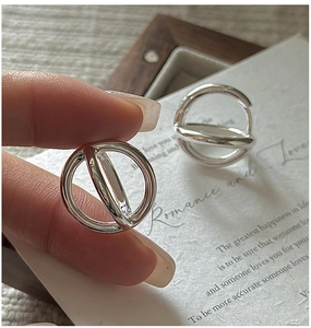 Close-up of S925 sterling silver geometric double hoop earrings held by hand
