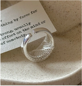 Macro shot of silver woven mesh texture on a minimalist S925 sterling silver open ring