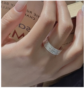 Close-up of a vintage S925 sterling silver brushed ring with a star pattern and sparkling stone