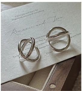 Close-up of S925 sterling silver minimalist crossover earrings with hallmark detail