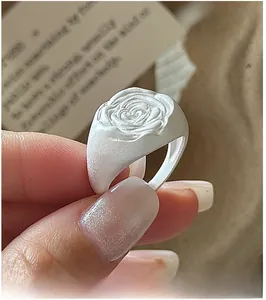 Detailed close-up of S925 silver rose ring featuring a matte white relief floral design