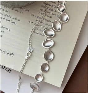 Close-up of S925 sterling silver necklace with matte oval pendants and lobster clasp