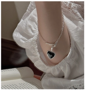 Close-up of S925 silver bracelet with black heart pendant and vintage OT buckle clasp