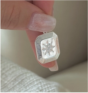 Detailed view of an S925 silver starburst pendant featuring a center zircon stone