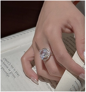Macro view of S925 sterling silver ring with cushion-cut crystal on French book page