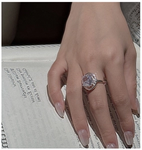 Detail of cushion cut white crystal ring on hand with elegant double halo setting