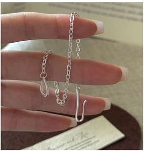 Detail of S925 sterling silver stamp on minimalist chain bracelet with retro clasp