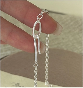 Detailed close-up of S925 sterling silver stamp on minimalist oval link bracelet