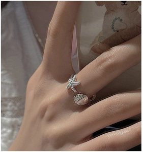Detailed close-up of S925 silver starfish and shell open ring with sparkling pavé stones