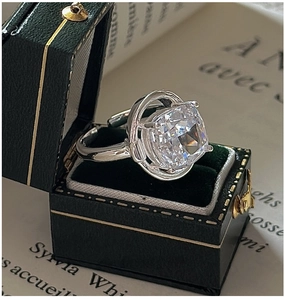 Macro detail of firework-cut white crystal ring on vintage book with velvet gift box