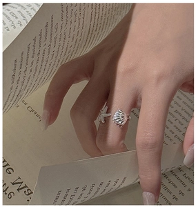 Detailed close-up of S925 silver shell and starfish open ring worn on a model's finger