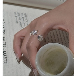 Close-up of S925 silver ring featuring realistic starfish and seashell carvings on hand