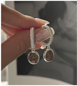 Detail of S925 silver hoop earrings featuring woven texture and quartz crystal pendants