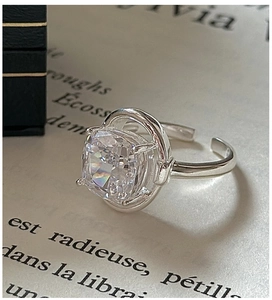 Macro detail of S925 sterling silver ring with cushion cut white crystal on a book