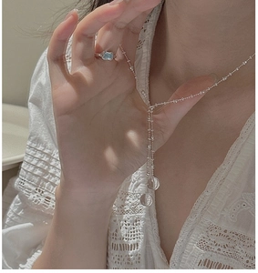 Close-up of S925 sterling silver Y-shaped necklace with clear spherical pendants on lace