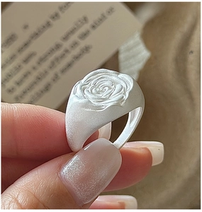Detailed close-up of matte S925 sterling silver ring with delicate rose flower relief