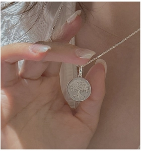 Detailed close-up of S925 silver Tree of Life pendant worn on a minimalist necklace