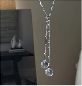 Detail of silver S925 Y-shaped necklace featuring dual transparent crystal ball pendants