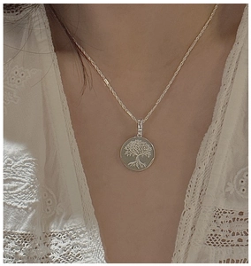Macro detail of S925 sterling silver Tree of Life pendant necklace worn by a model