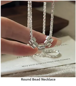 Macro shot of S925 sterling silver cylinder bead necklace held by a hand model