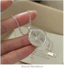 Detailaufnahme des Ag925 Sterlingsilber-Anhängers mit Sonnenstrahl-Textur und kleinem Stein