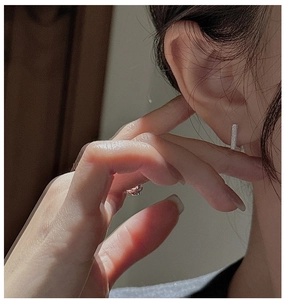 Detail of silver rectangular earrings with shimmering texture on a female model