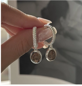 Macro detail of S925 silver twist earrings with vintage oval rutilated quartz pendant