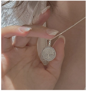 Detail shot of S925 sterling silver Tree of Life pendant with delicate rope chain on model