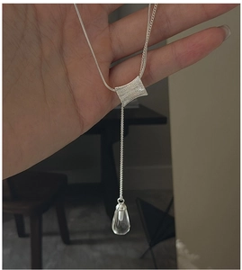 Détail d'un collier en argent S925 avec franges et pendentif en cristal transparent
