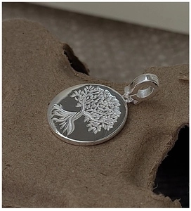 Macro detail of S925 sterling silver Tree of Life pendant with polished metal finish