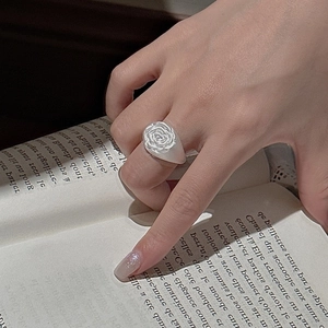Retro S925 silver rose flower ring with frosted matte band on a vintage book backdrop