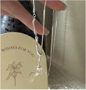 Detail of silver snake chain with fluid metal lava pendant and clear water drop bead