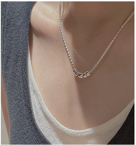 Close-up of minimalist S925 sterling silver popcorn chain necklace with five bead pendant