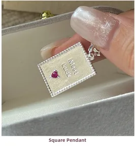 Macro view of S925 silver square pendant featuring red heart gem and Meet Luck text