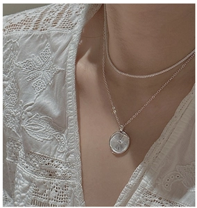 Detail der silbernen S925-Doppelkette mit sternengraviertem Rundanhänger und engem Choker