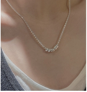 Detailed view of S925 silver popcorn chain necklace with five cylindrical beads on neck