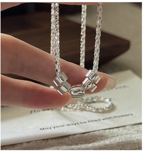 Macro shot of S925 sterling silver popcorn chain necklace featuring five smooth cylinder beads