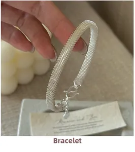 Detail of silver mesh bracelet featuring a heart pendant and secure S-hook clasp