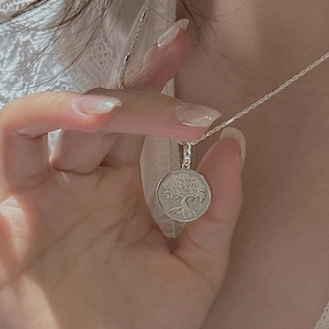 S925 sterling silver Tree of Life pendant necklace on model in natural sunlight
